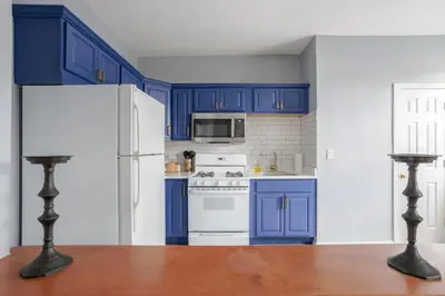 a blue kitchen with white appliances and blue cabinets at One BR near Metlife with Laundry & Parking in Lodi