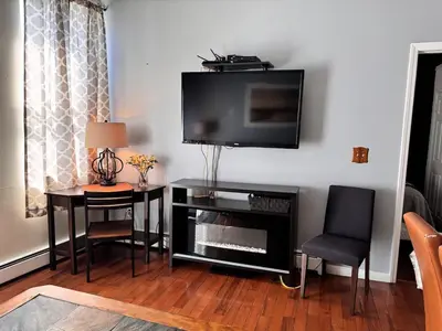 a living room with a flat screen tv on a wall at New York Skyline One of a Kind View in Union City