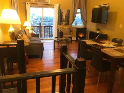 a living room with a couch and a table and a fireplace at New York Skyline One of a Kind View in Union City