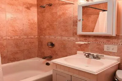 a bathroom with a sink and a tub and a mirror at NY-NJ Tennis Suites - Sleeps 40 - 15 Mins to NYC in Union City