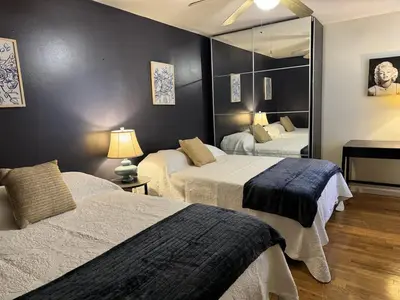 a bedroom with two beds and a mirror at NY-NJ Tennis Suites - Sleeps 40 - 15 Mins to NYC in Union City