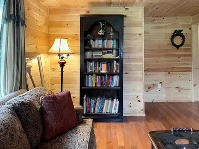a living room with a book shelf filled with books at Fern Hollow Home