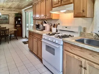 a kitchen with a white stove and a sink at Fern Hollow Home