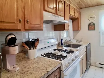 a kitchen with a white stove and a sink at Fern Hollow Home