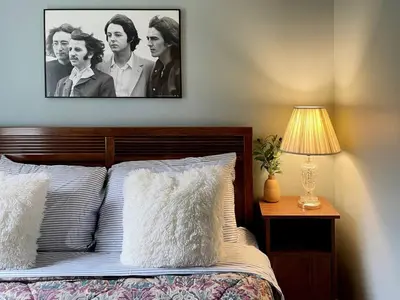 a bedroom with a bed with a picture on the wall at Fern Hollow Home