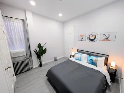 a bedroom with a large bed and a window at Newly Renovated 2B 2BA apt! mins to PATH & NY! in Jersey City