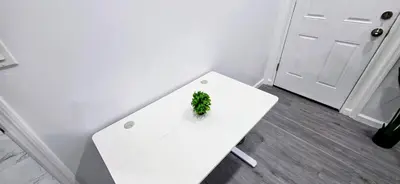 a white table with a plant on it next to a door at Newly Renovated 2B 2BA apt! mins to PATH & NY! in Jersey City