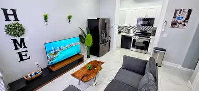 a living room with a couch and a flat screen tv at Newly Renovated 2B 2BA apt! mins to PATH & NY! in Jersey City