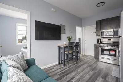 a living room with a couch and a table and a kitchen at Two BR near Metlife with Laundry & Parking in Lodi