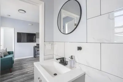 a white bathroom with a sink and a mirror at Two BR near Metlife with Laundry & Parking in Lodi