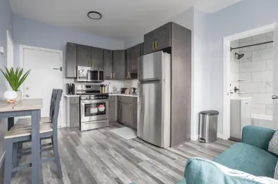a kitchen with stainless steel appliances and wooden cabinets at Two BR near Metlife with Laundry & Parking in Lodi