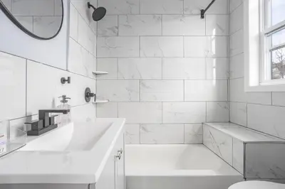 a white bathroom with a tub and a sink at Two BR near Metlife with Laundry & Parking in Lodi