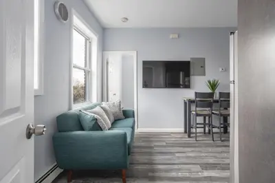 a living room with a blue couch and a kitchen at Two BR near Metlife with Laundry & Parking in Lodi