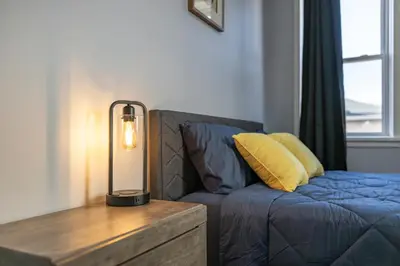 a lamp sitting on a table next to a couch at Three BR near Metlife with Laundry & Parking in Lodi