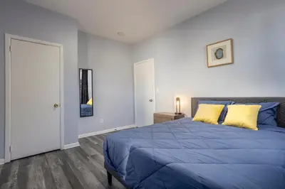 a bedroom with a blue bed with yellow pillows at Three BR near Metlife with Laundry & Parking in Lodi