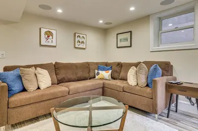 a living room with a brown couch and a glass table at Walk to Hudson River Parks Recently Renovated Apt in Hoboken