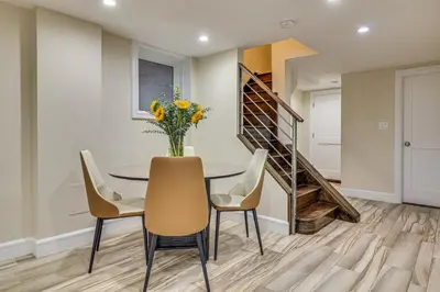 a dining room with a table and chairs with a vase of flowers at Walk to Hudson River Parks Recently Renovated Apt in Hoboken