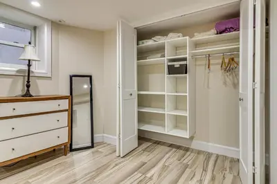 a walk in closet with a dresser and a mirror at Walk to Hudson River Parks Recently Renovated Apt in Hoboken