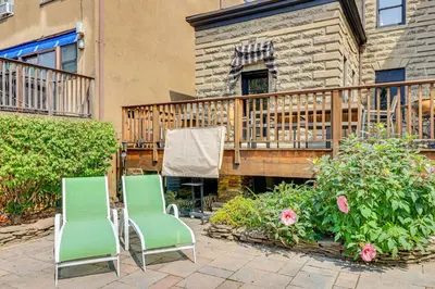 two green chairs sitting on a patio with a deck at Walk to Hudson River Parks Recently Renovated Apt in Hoboken