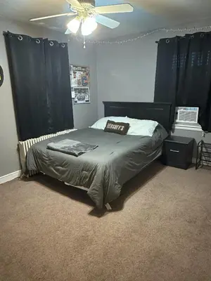 a bedroom with a bed with black curtains and a ceiling fan at Cozy 1 BR Retreat within walking distance to all the Hershey Attractions in Hershey