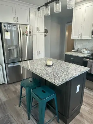 a kitchen with a granite counter top and blue stools at Cozy 1 BR Retreat within walking distance to all the Hershey Attractions in Hershey