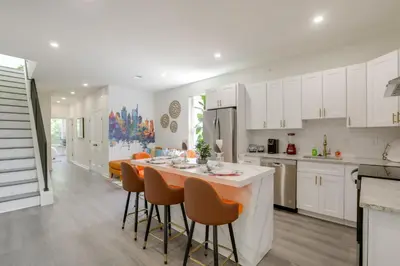 a kitchen with white cabinets and a table and chairs at Penthouse Condo with Rooftop Deck in Philadelphia! in Philadelphia