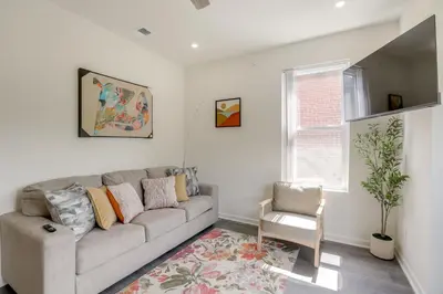 a living room with a couch and a chair at Penthouse Condo with Rooftop Deck in Philadelphia! in Philadelphia