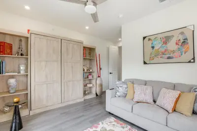 a living room with a couch and a book shelf at Penthouse Condo with Rooftop Deck in Philadelphia! in Philadelphia