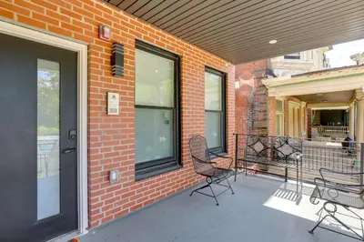 a porch with two chairs and a brick building at Penthouse Condo with Rooftop Deck in Philadelphia! in Philadelphia