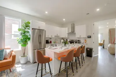 a kitchen with a large island with bar stools at Penthouse Condo with Rooftop Deck in Philadelphia! in Philadelphia