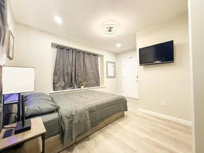 a bedroom with a bed and a flat screen tv at Town & Country Andover, NJ Area- Studio Unit in Newton