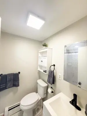 a bathroom with a white toilet and a sink at Town & Country Andover, NJ Area- Studio Unit in Newton