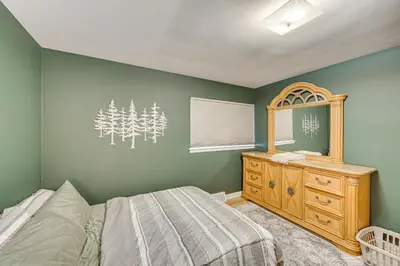 a bedroom with a bed and a dresser and a mirror at Near Dtwn Harrisburg Stylish Home with Patio and Yard in Camp Hill