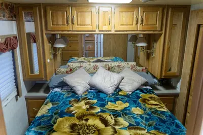 a bedroom with a bed with yellow flowers on it at Art Rv motorhome in Quakertown
