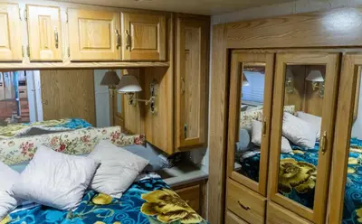 a bedroom with two beds and wooden cabinets at Art Rv motorhome in Quakertown