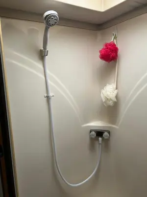 a shower with a red flower on a wall at Art Rv motorhome in Quakertown