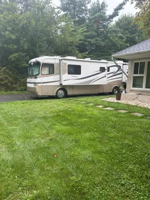 a rv parked in a yard next to a house at Art Rv motorhome in Quakertown