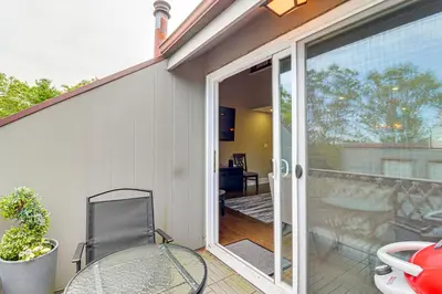 a patio with a glass door and a table and chair at Modern Mountain Escape in Poconos Walk to Slopes! in Tannersville