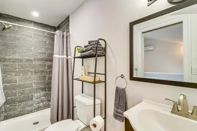 a bathroom with a toilet and a sink and a mirror at Modern Mountain Escape in Poconos Walk to Slopes! in Tannersville