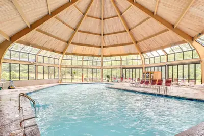 an indoor swimming pool with a large building with windows at Modern Mountain Escape in Poconos Walk to Slopes! in Tannersville