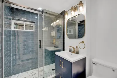 a bathroom with a sink and a shower with blue tiles at Cozy Garden 1Bed Apt, Lincoln Park in Jersey City