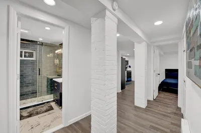 a hallway of a home with a white brick pillar at Cozy Garden 1Bed Apt, Lincoln Park in Jersey City