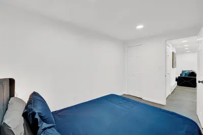a bedroom with a blue bed and a white wall at Cozy Garden 1Bed Apt, Lincoln Park in Jersey City