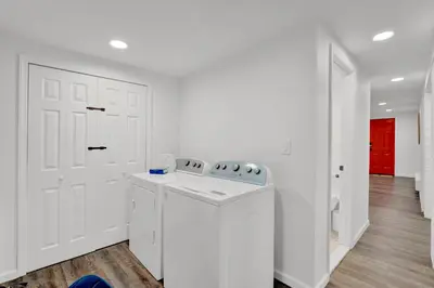 a white kitchen with a stove and a white door at Cozy Garden 1Bed Apt, Lincoln Park in Jersey City