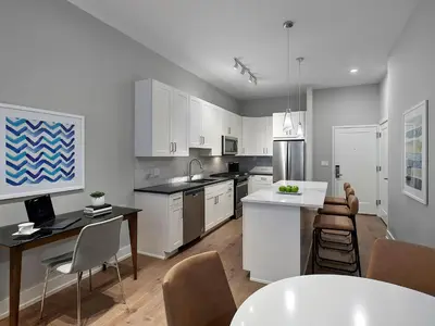 a kitchen with white cabinets and a table and chairs at AVE Blue Bell - Short Stay Furnished Apartment in Blue Bell