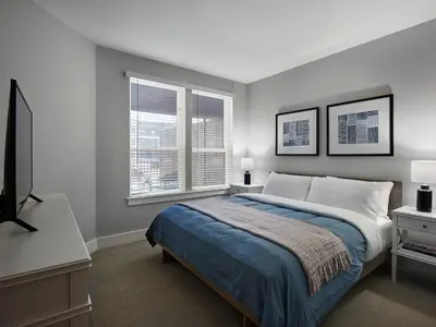a bedroom with a bed and a desk and two windows at AVE Blue Bell - Short Stay Furnished Apartment in Blue Bell