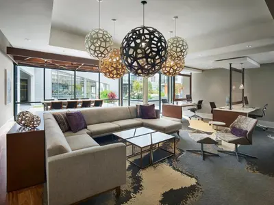 a living room with a couch and tables and windows at AVE King of Prussia - Short Stay Furnished Apartment in King of Prussia