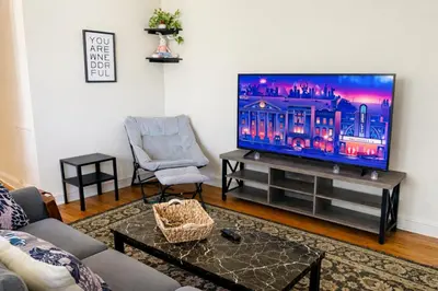 a living room with a flat screen tv and a chair at 1BR Near Philly Free Parking, Monthly Discount in Philadelphia
