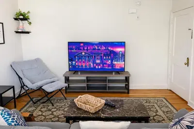 a living room with a flat screen tv and a chair at 1BR Near Philly Free Parking, Monthly Discount in Philadelphia