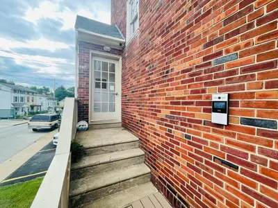 a brick building with a white door on the side of it at 1BR Near Philly Free Parking, Monthly Discount in Philadelphia